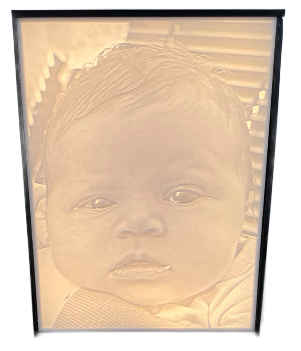 Babyportret in een zwarte lijst met een zachte sepia-achtergrond en een gestreept shirt, kijkend naar de camera.