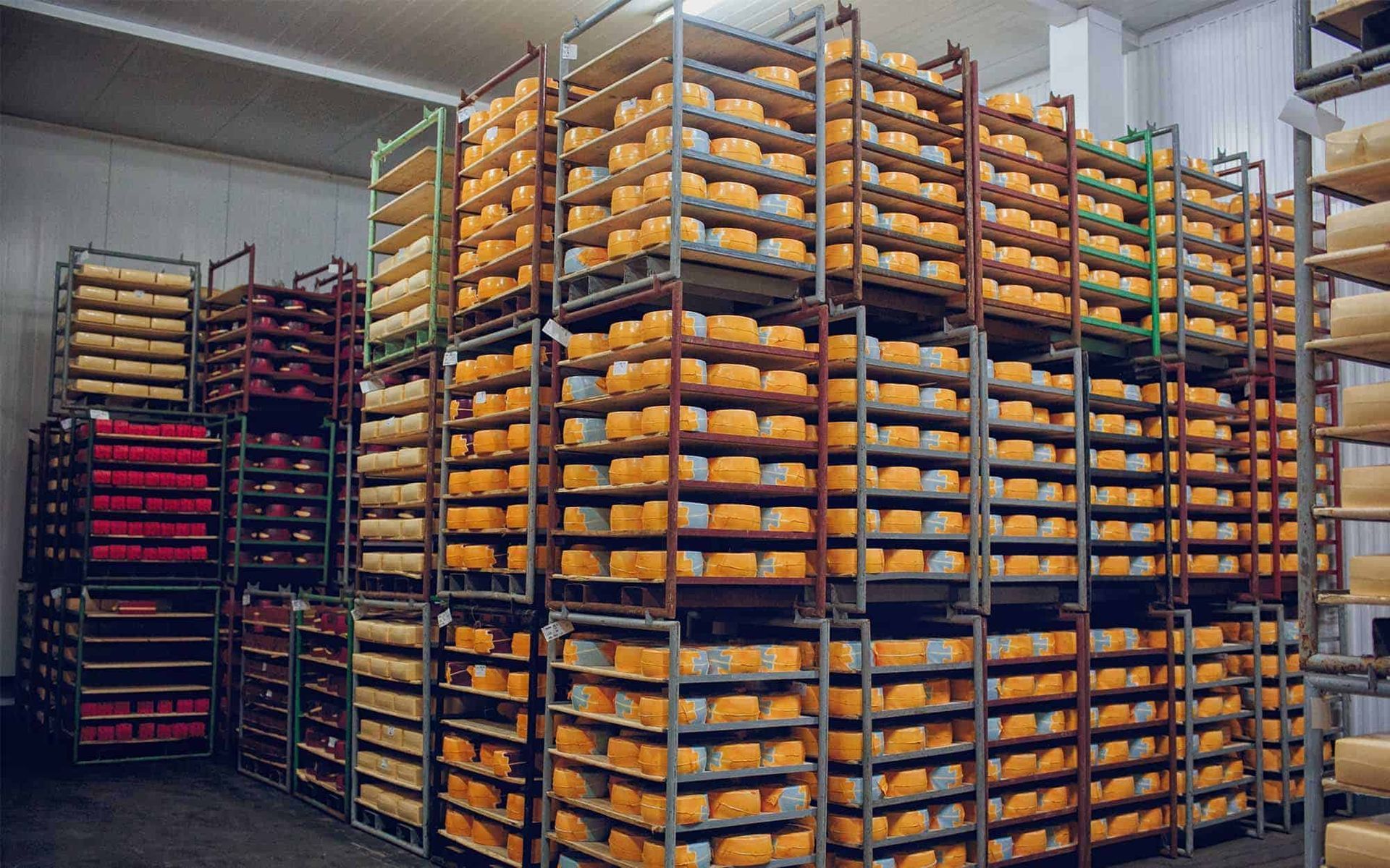 Industrial warehouse shelves stacked with rows of orange and red packaged goods