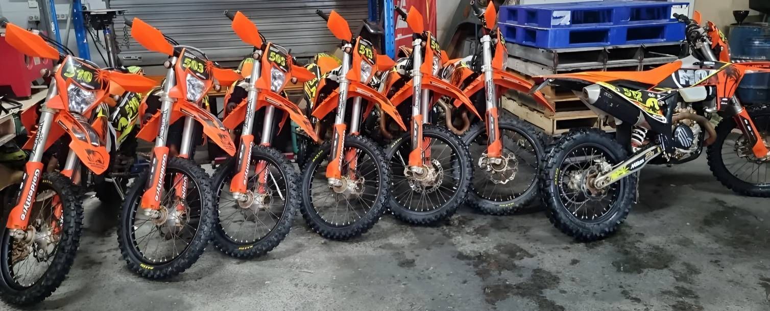 A Row Of Dirt Bikes Are Parked In A Garage — Motorcycle Transporters In Manunda, QLD