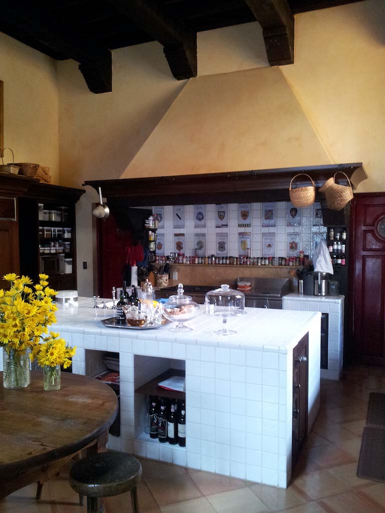 image of a large kitchen with a white tile worktop and a large fireplace with yellow intonachino product walls