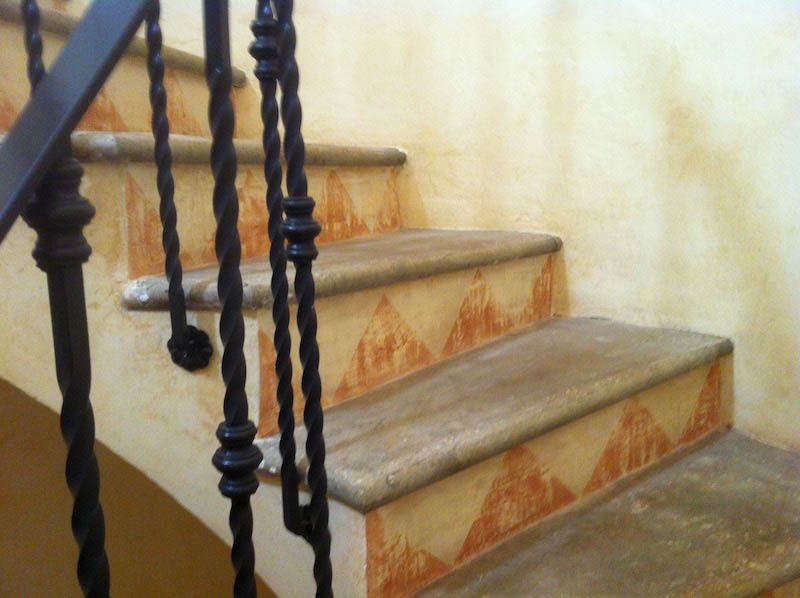picture of an external stair decorated with yellow and orange triangles made by venezia stucco lime paint product for an ancient effect