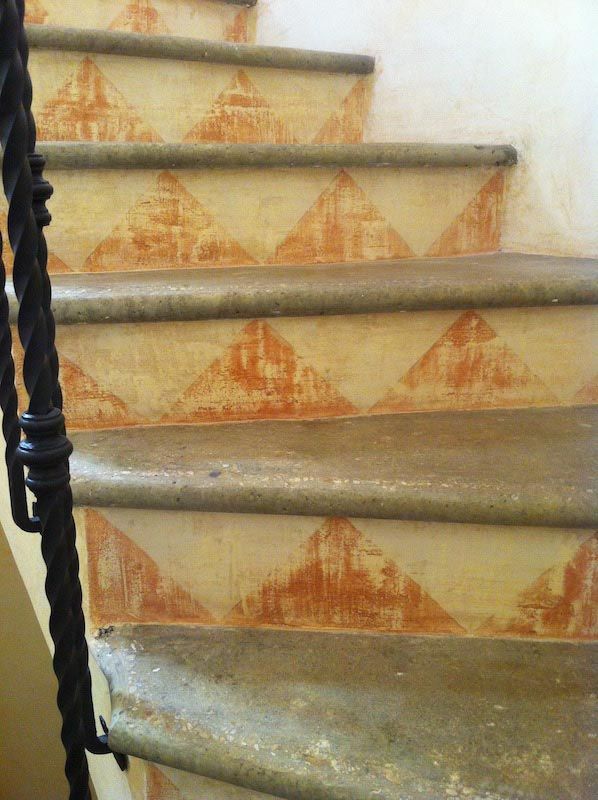 front picture of an external stair decorated with yellow and orange triangles made by venezia stucco lime paint product for an ancient effect