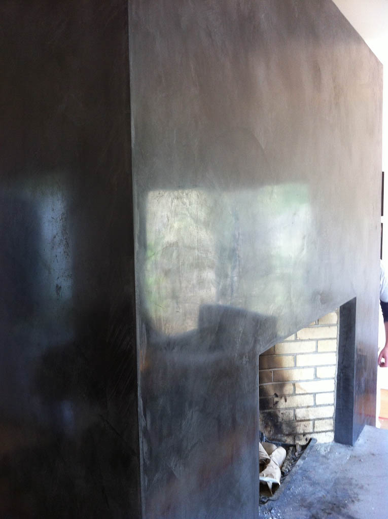 fireplace with glossy black marmorino walls