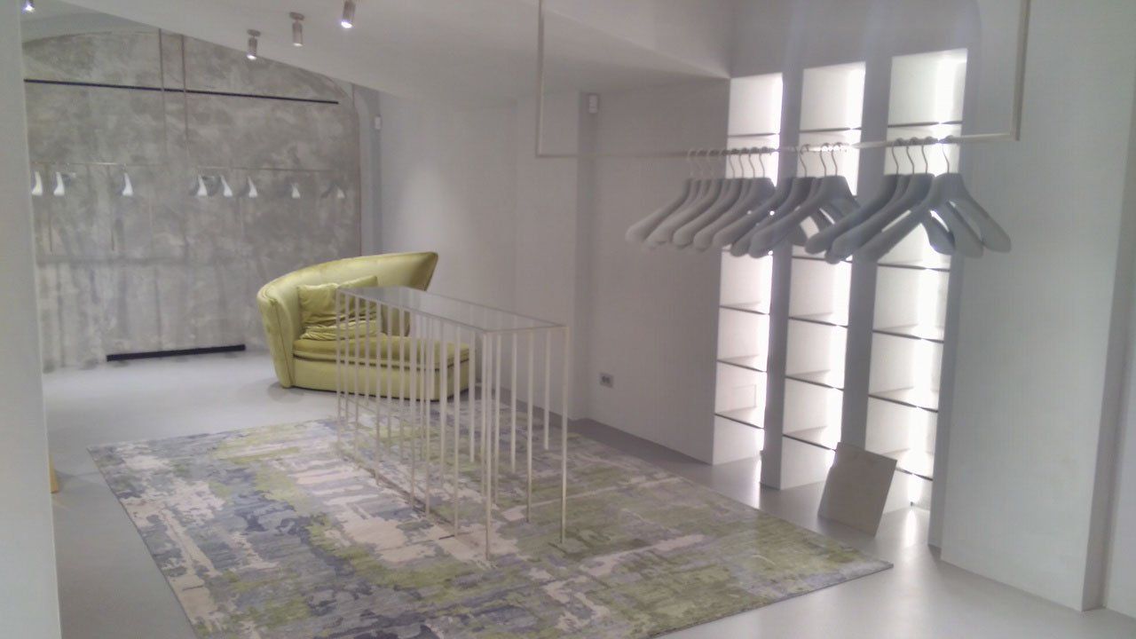 venezia stucco image of the interior of a clothing store with white venetian marmorino walls and floor and a green decorative sofa