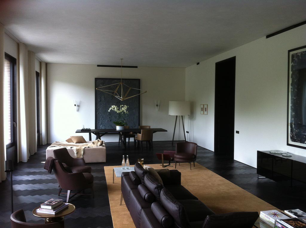 picture of a room with brown sofas and white suede walls