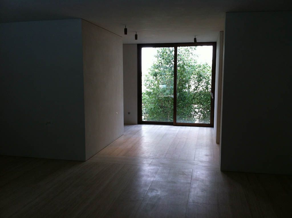 picture of an interior with a big bright window and wooden floor with white suede wall and roof product