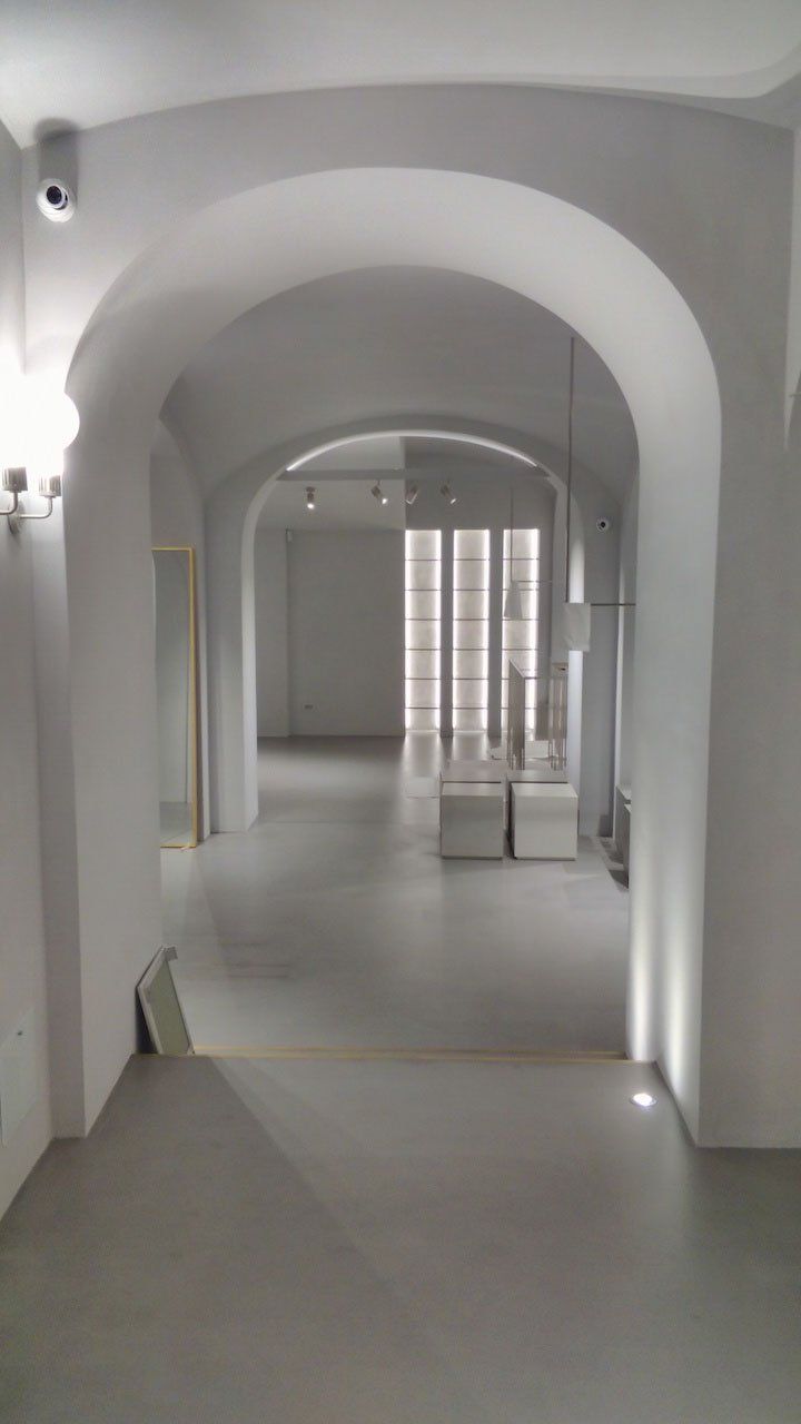 picture of a bright interior with arch and three vertical lamps with white suede walls product and white pastellone floor