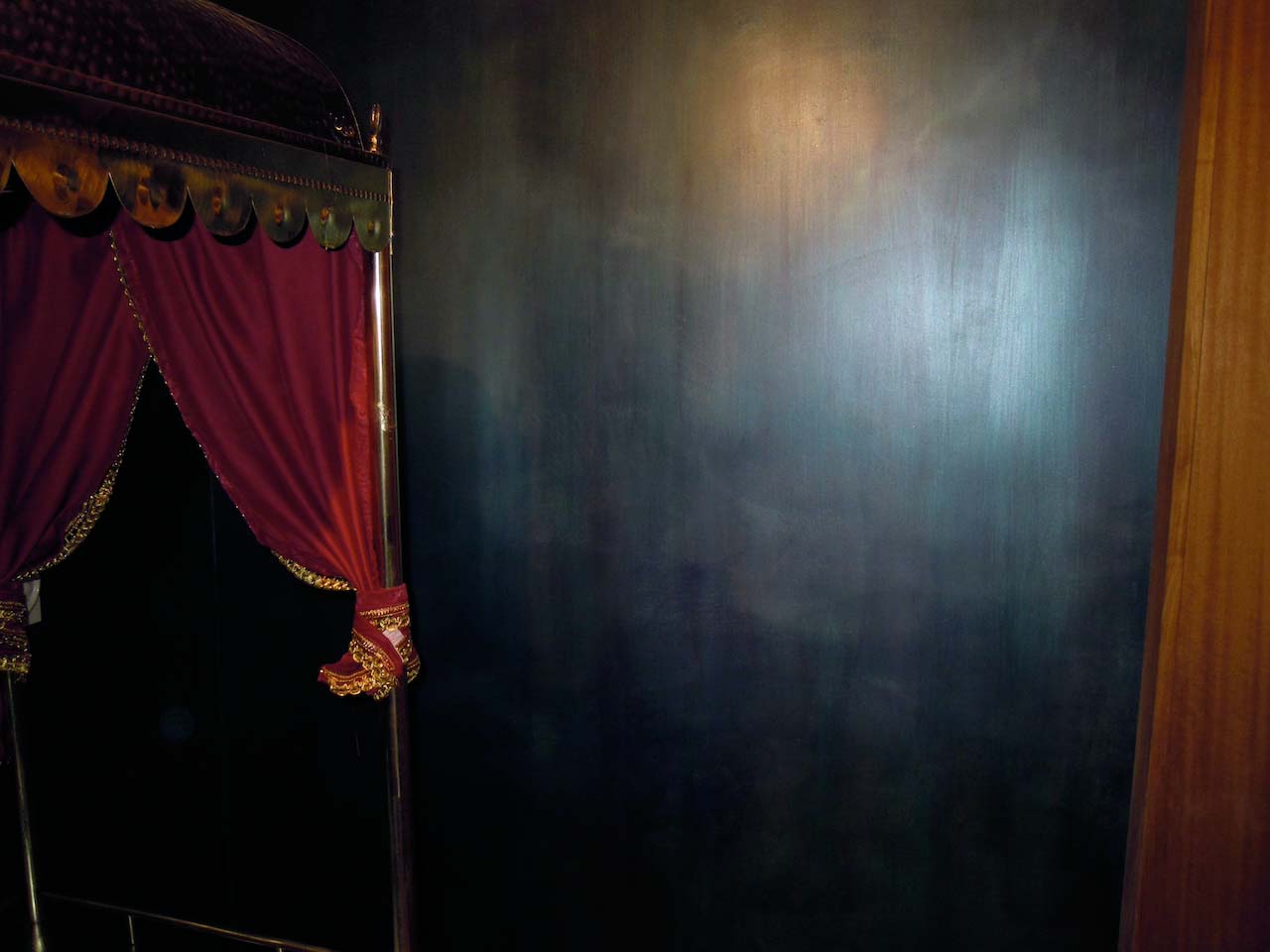 detail of a black wall made with tadelakt product and a red tent