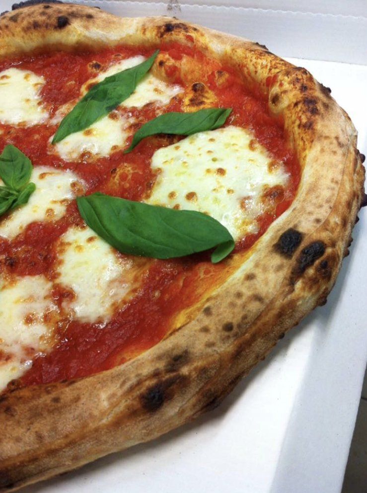 Una pizza con salsa di pomodoro e formaggio su un piatto bianco