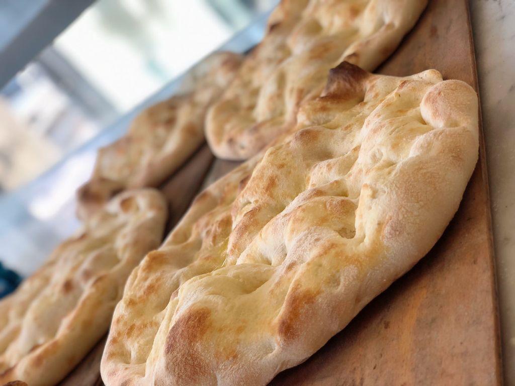Un mucchio di pane è appoggiato su un tagliere di legno.