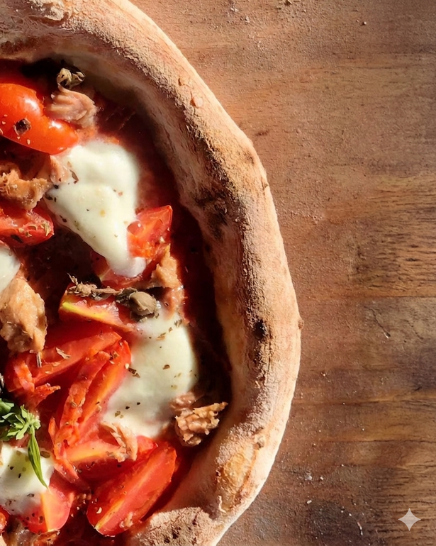 Primo piano di una pizza vegetariana con formaggio fuso su un tavolo di legno.