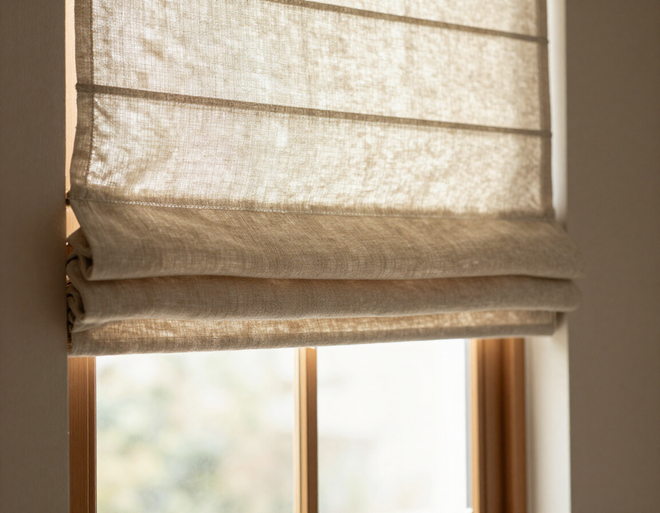 Soft roman shade in neutral linen fabric in a bedroom