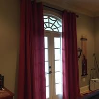 French doors with burgundy curtains in a warmly lit room