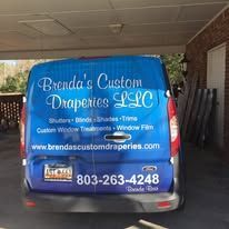 Blue van under a carport advertising Brenda’s Custom Draperies LLC with website and phone number on the rear.
