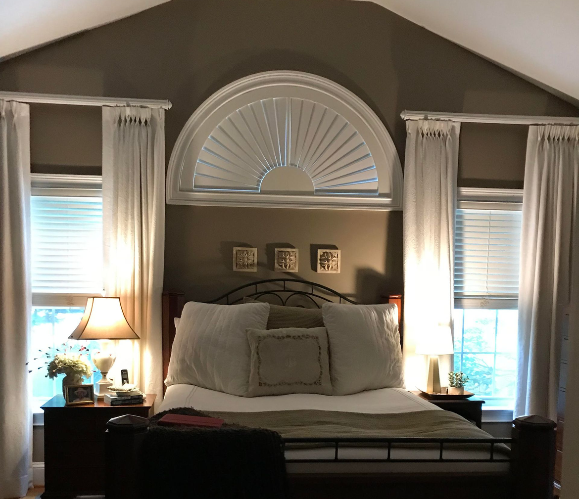Plantation shutters on a wide bay window in a Southern-style living room