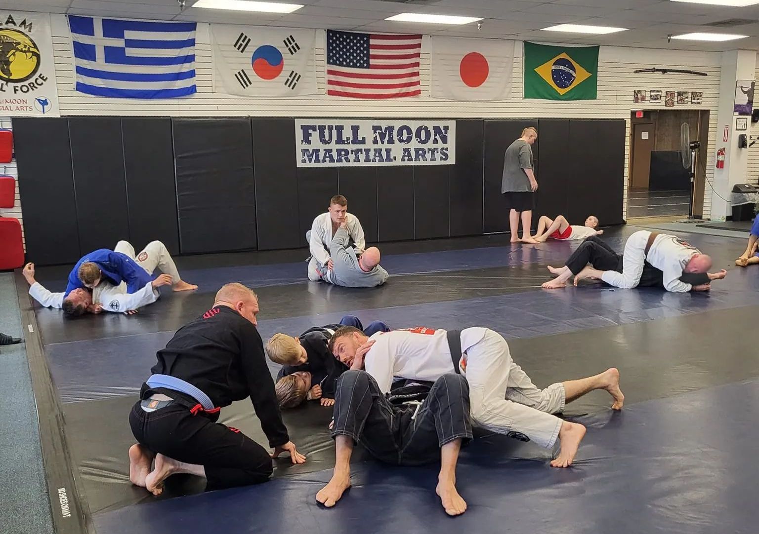 People training Jiu-Jitsu on mats at 