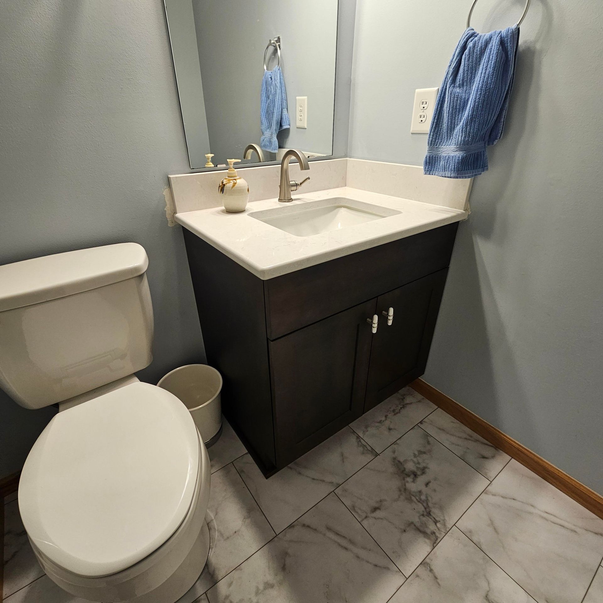 A bathroom with a toilet , sink and mirror