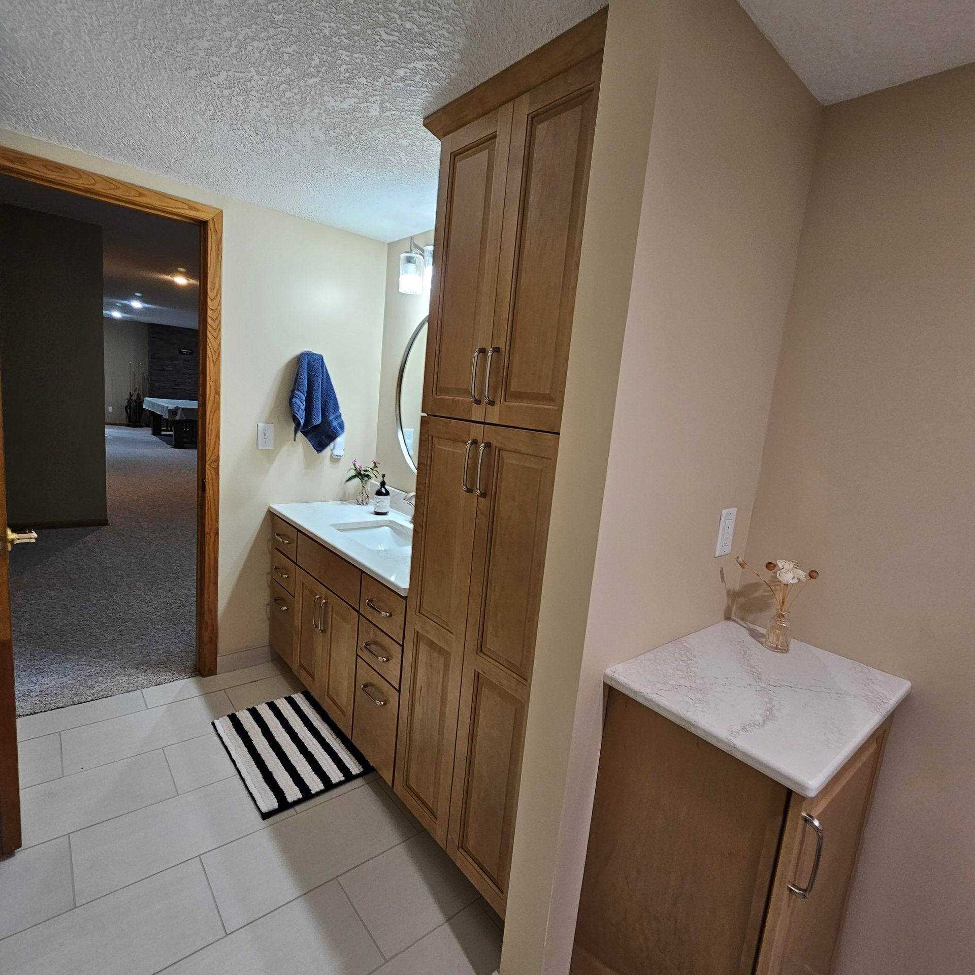 A bathroom with wooden cabinets and a marble counter top