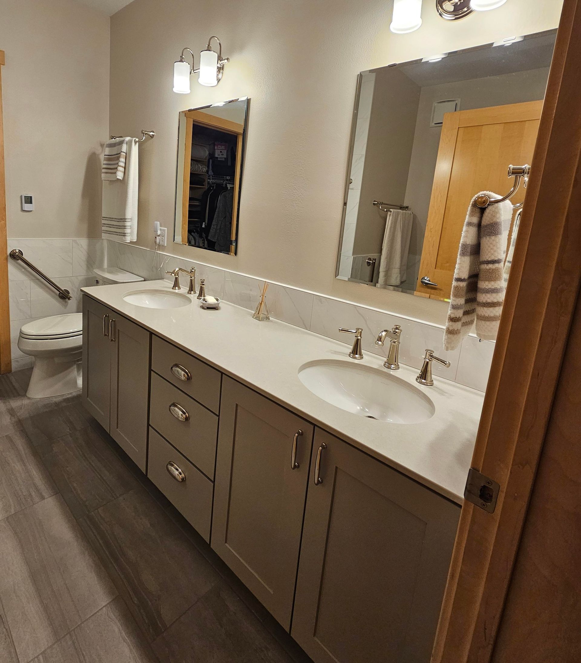 A bathroom with two sinks , a toilet and a mirror