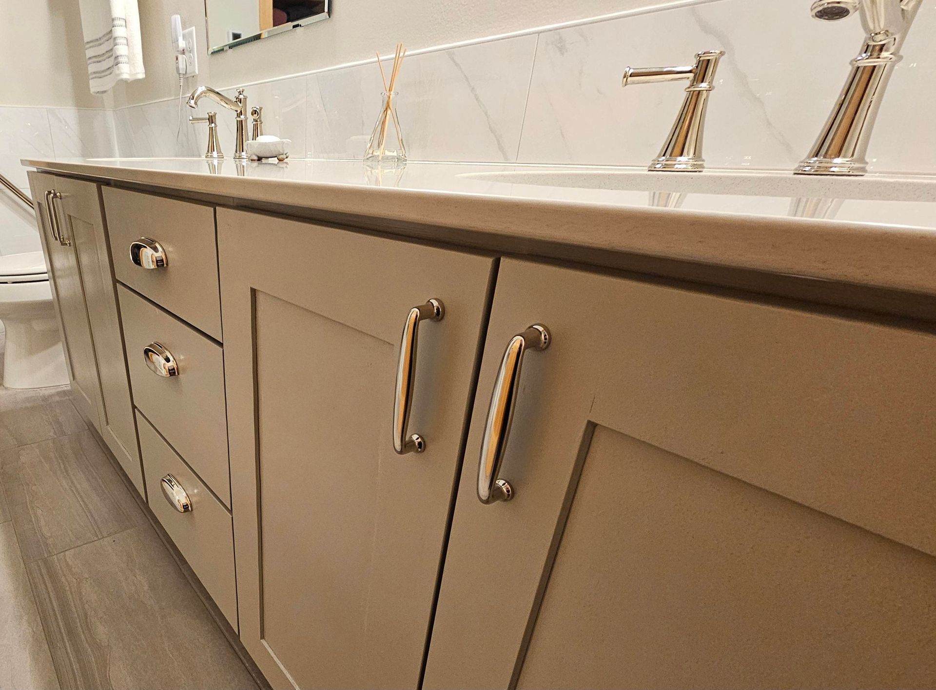 A bathroom with two sinks , a toilet and a mirror.