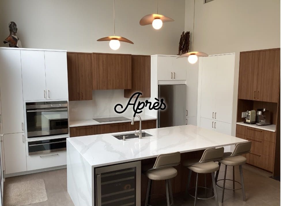 Rénovation de cuisine moderne avec armoires blanches et brunes, îlot avec sièges et luminaires suspendus.