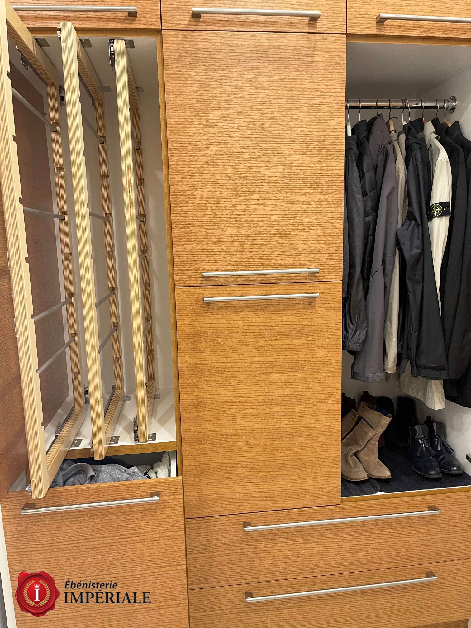Armoire en bois avec penderie coulissante à gauche, vêtements sur une tringle dans la partie droite et tiroirs en dessous.