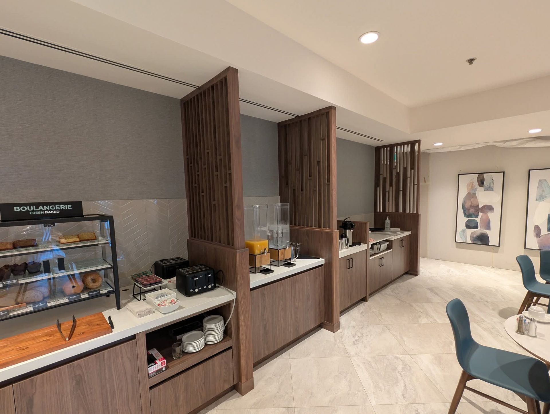 Espace buffet petit-déjeuner avec comptoirs, séparateurs en bois et présentoirs à plats.