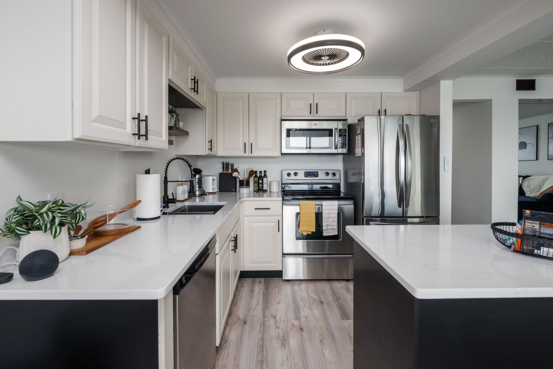 Modern kitchen with white cabinets, stainless steel appliances, and dark gray island.