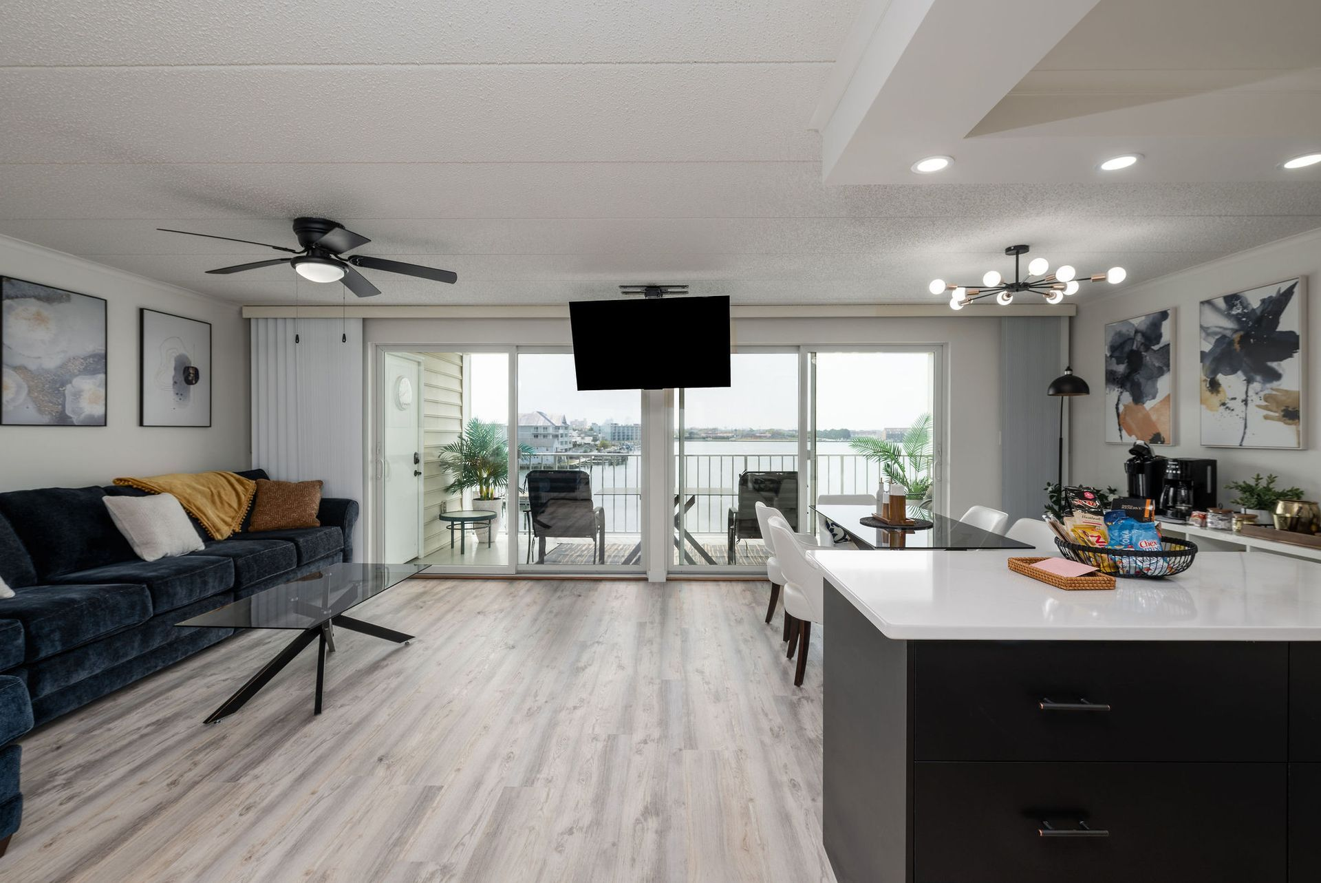 Modern living room with open layout, sliding doors, and water view.