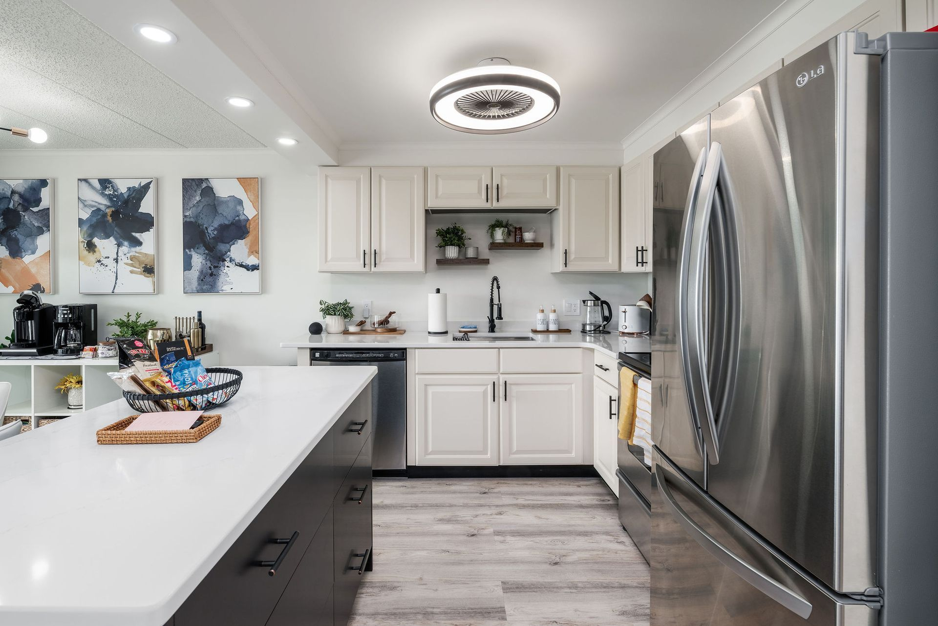 Modern kitchen with white cabinets, stainless steel appliances, and a large island.