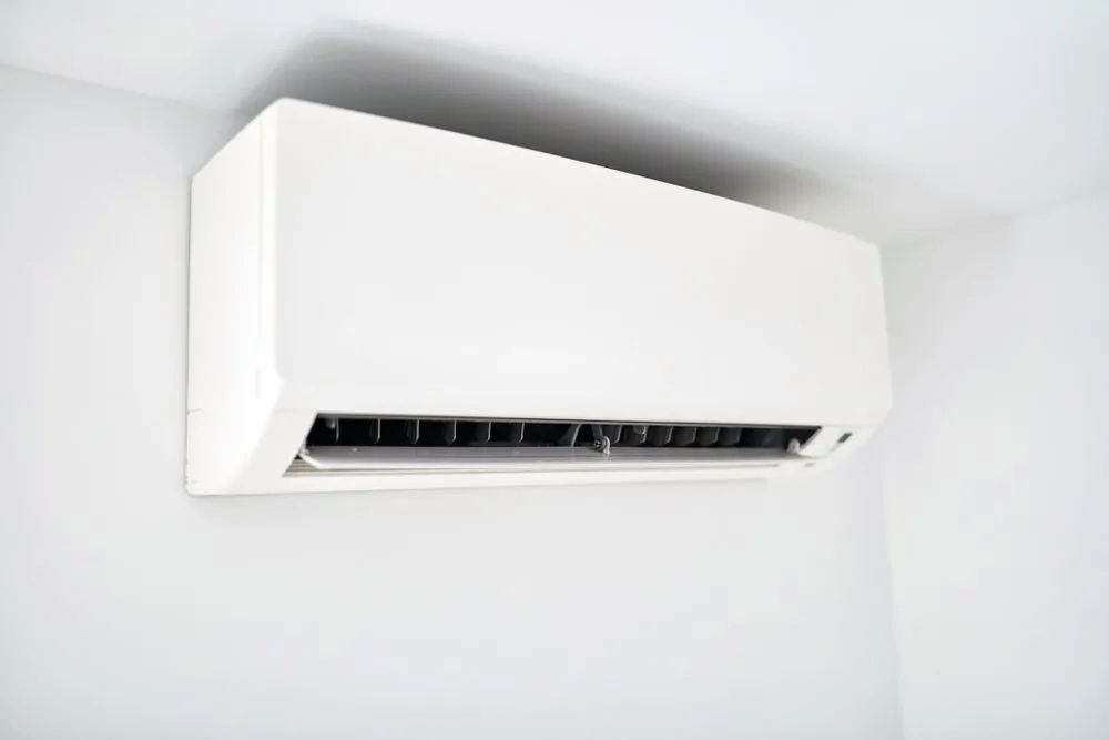 A White Air Conditioner Is Hanging From The Ceiling In A Room — Mackies In Port Macquarie, NSW