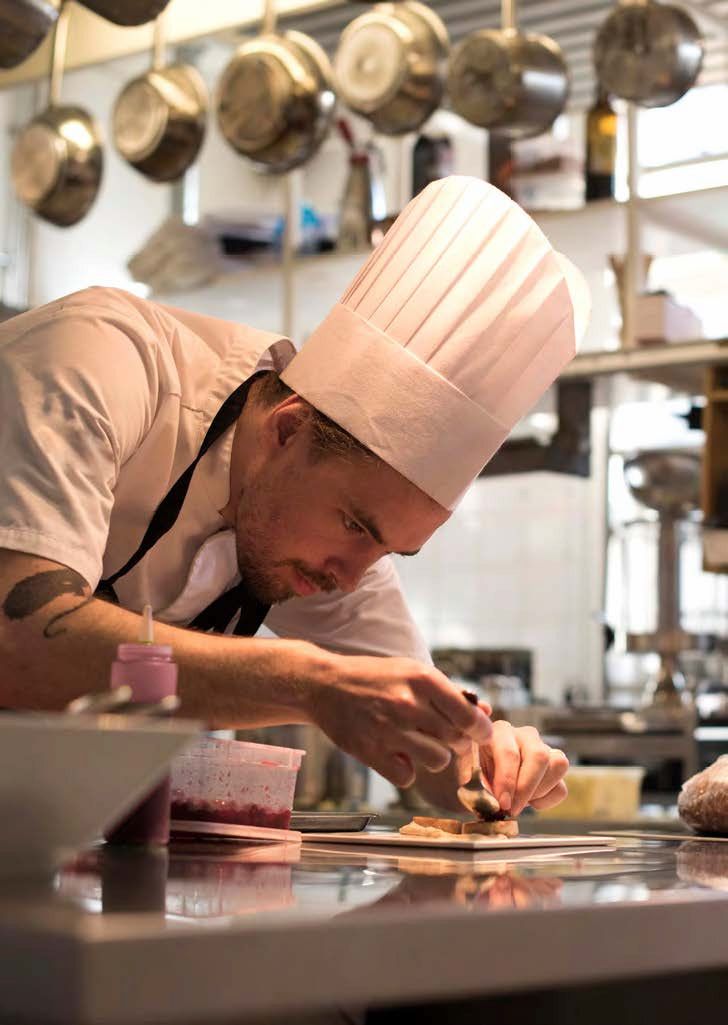 A Man In A Chef's Hat Is Preparing Food In A Kitchen — Mackies In Taree, NSW