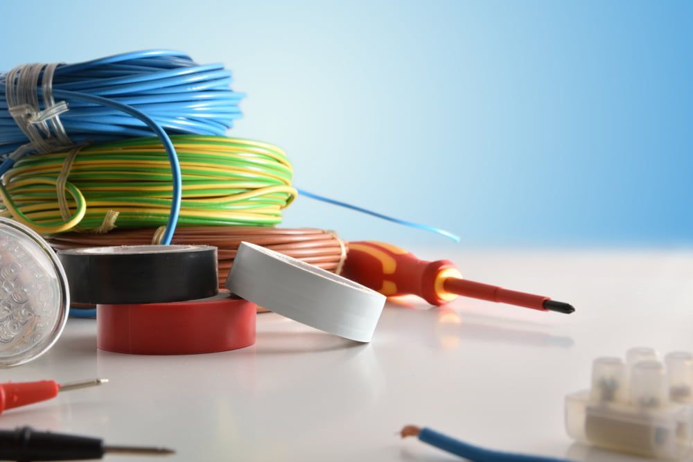 A Stack Of Wires, Tape, A Screwdriver, And A Light Bulb On A Table — Mackies In North Haven, NSW