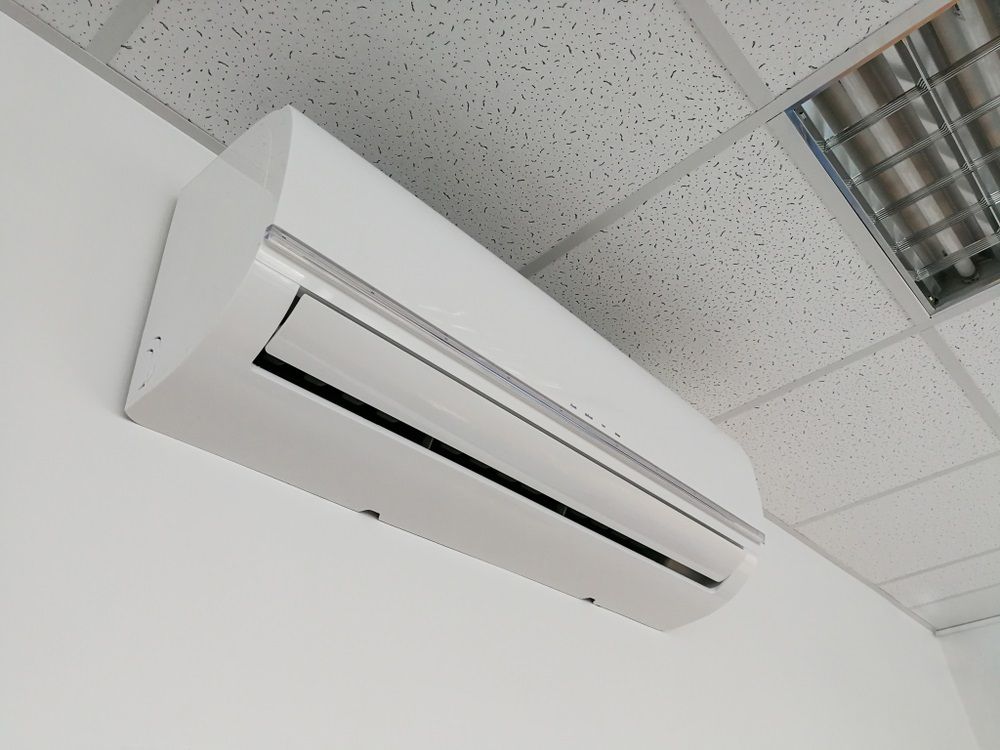 White Air Conditioning Unit Mounted On A White Wall — Mackies In Forster, NSW