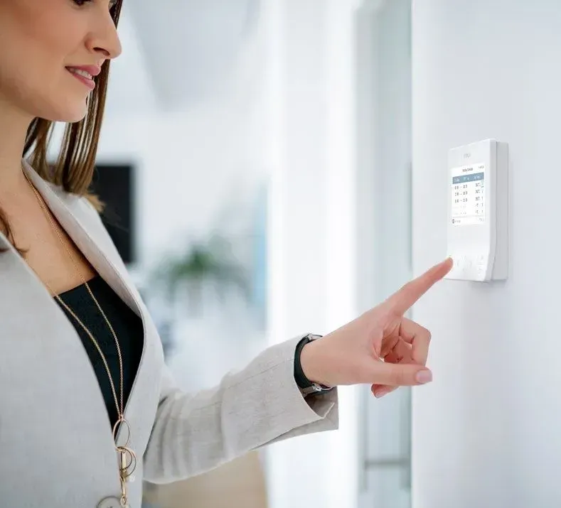 Woman In A Blazer Interacting With A White Security Keypad — Mackies In Taree, NSW