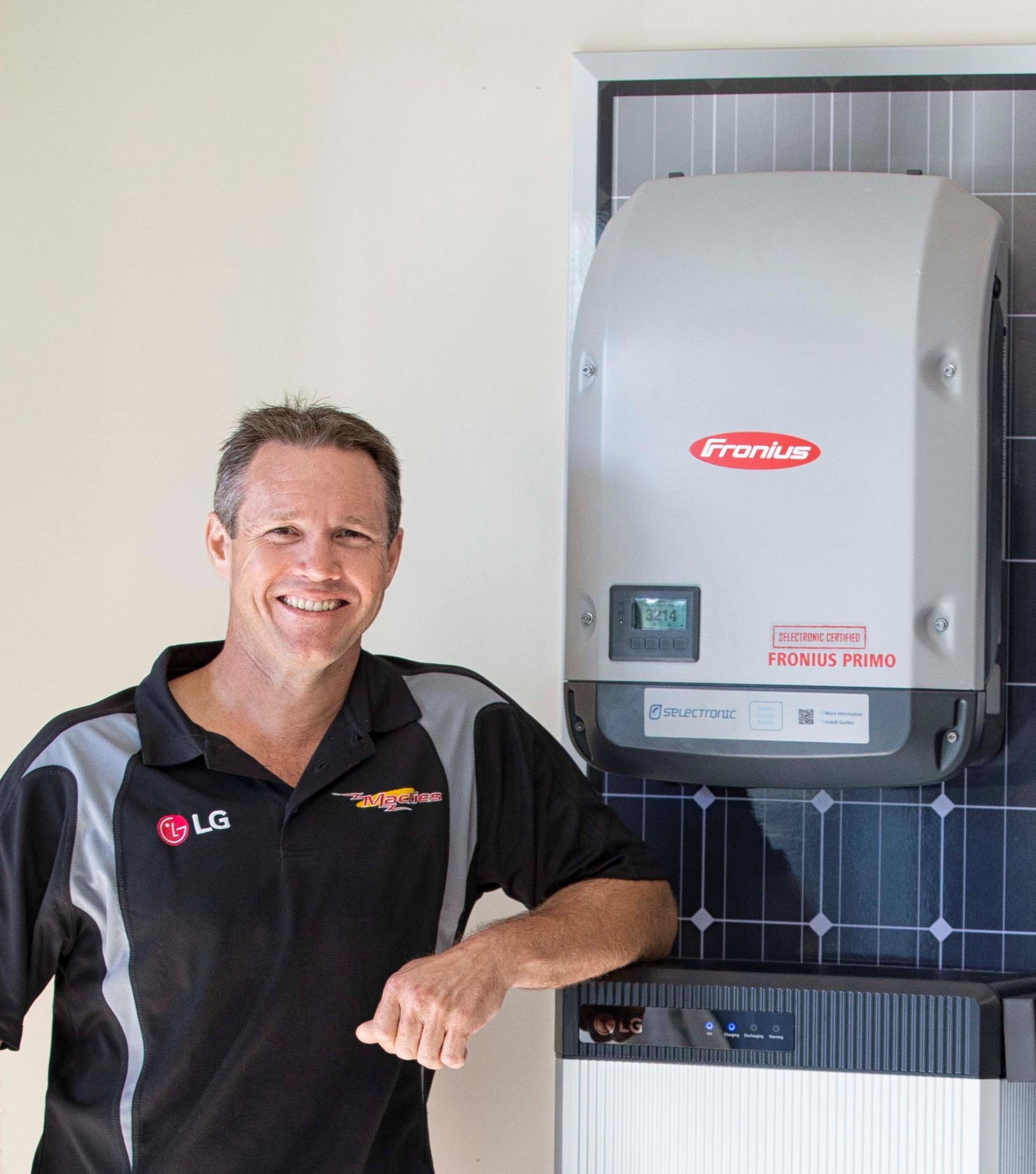 Man Smiling Next To Solar Panel Equipment — Mackies in Taree, NSW