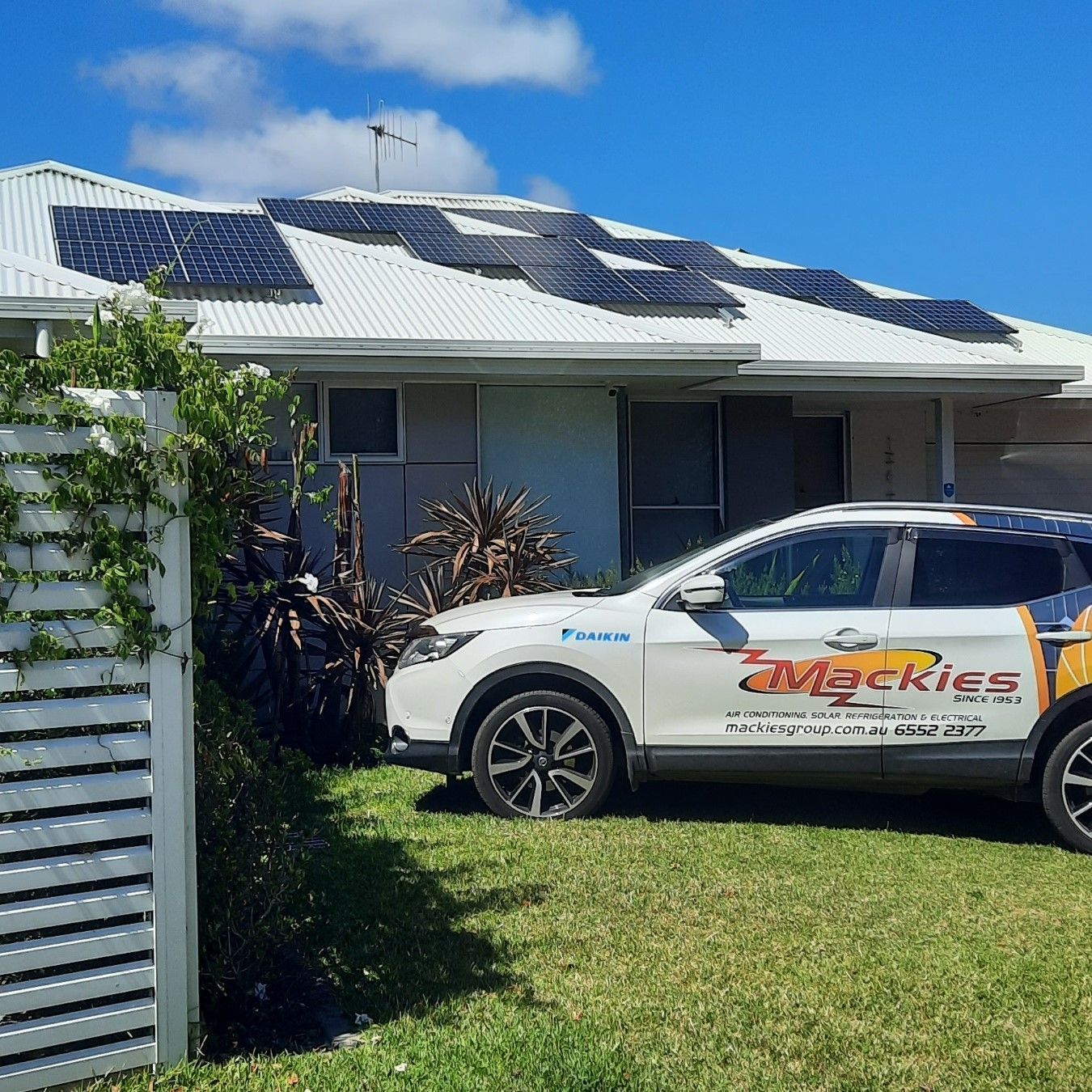Solar Panels On A House Roof With A Mackies Branded Car Parked — Mackies In Taree, NSW