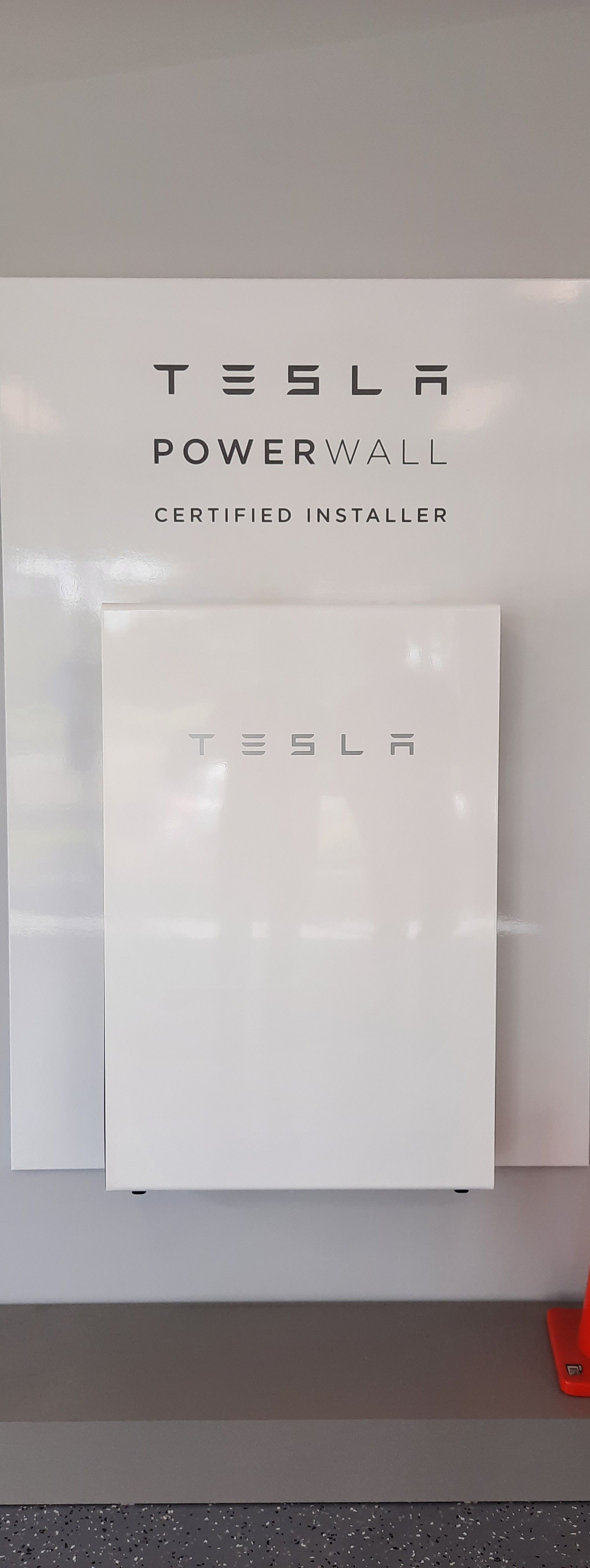 Tesla Powerwall Battery Mounted On A Wall, With Tesla Branding — Mackies in Taree, NSW