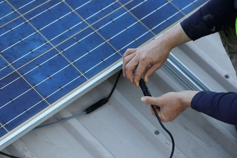 A Person Is Working On A Solar Panel On A Roof — Mackies In Old Bar, NSW