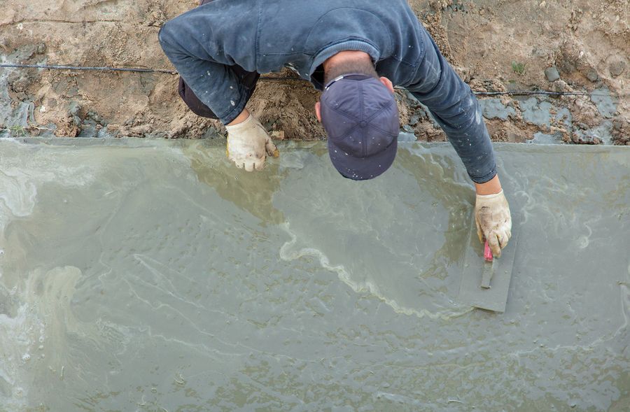 a man in a blue shirt and hat standing in mud