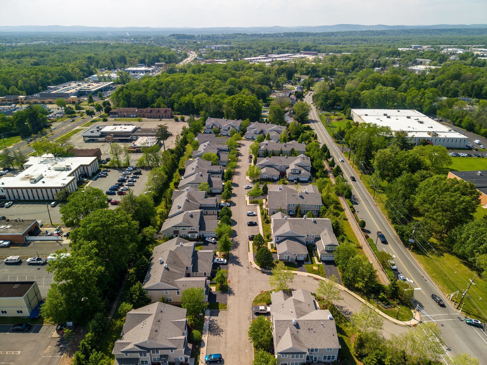 Aerial view of a suburban apartment complex with tree-lined streets and parking lots. Aerial view of a suburban apartment complex with tree-lined streets and parking lots.