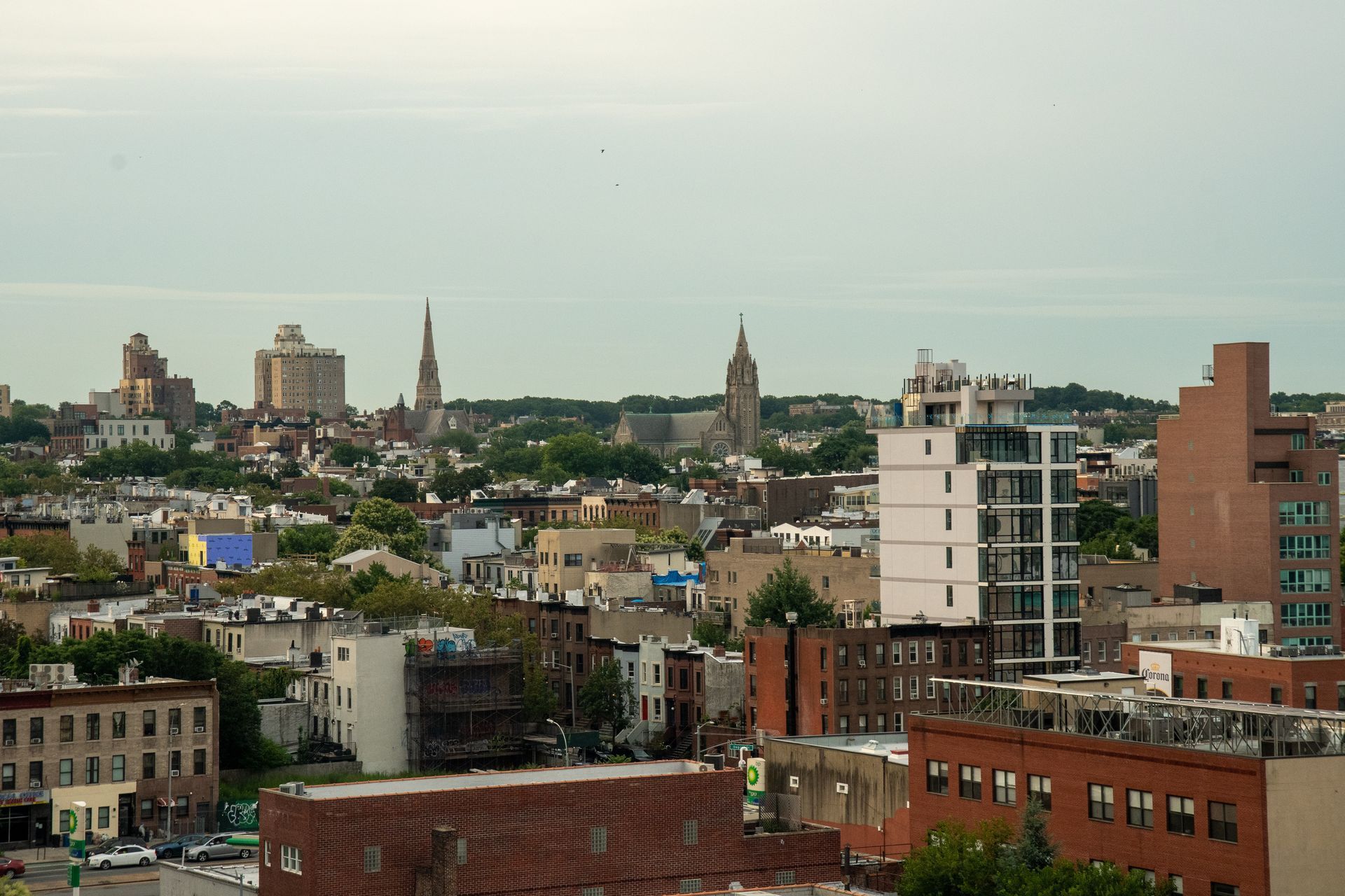 City skyline with low-rise buildings and church spires under a hazy sky