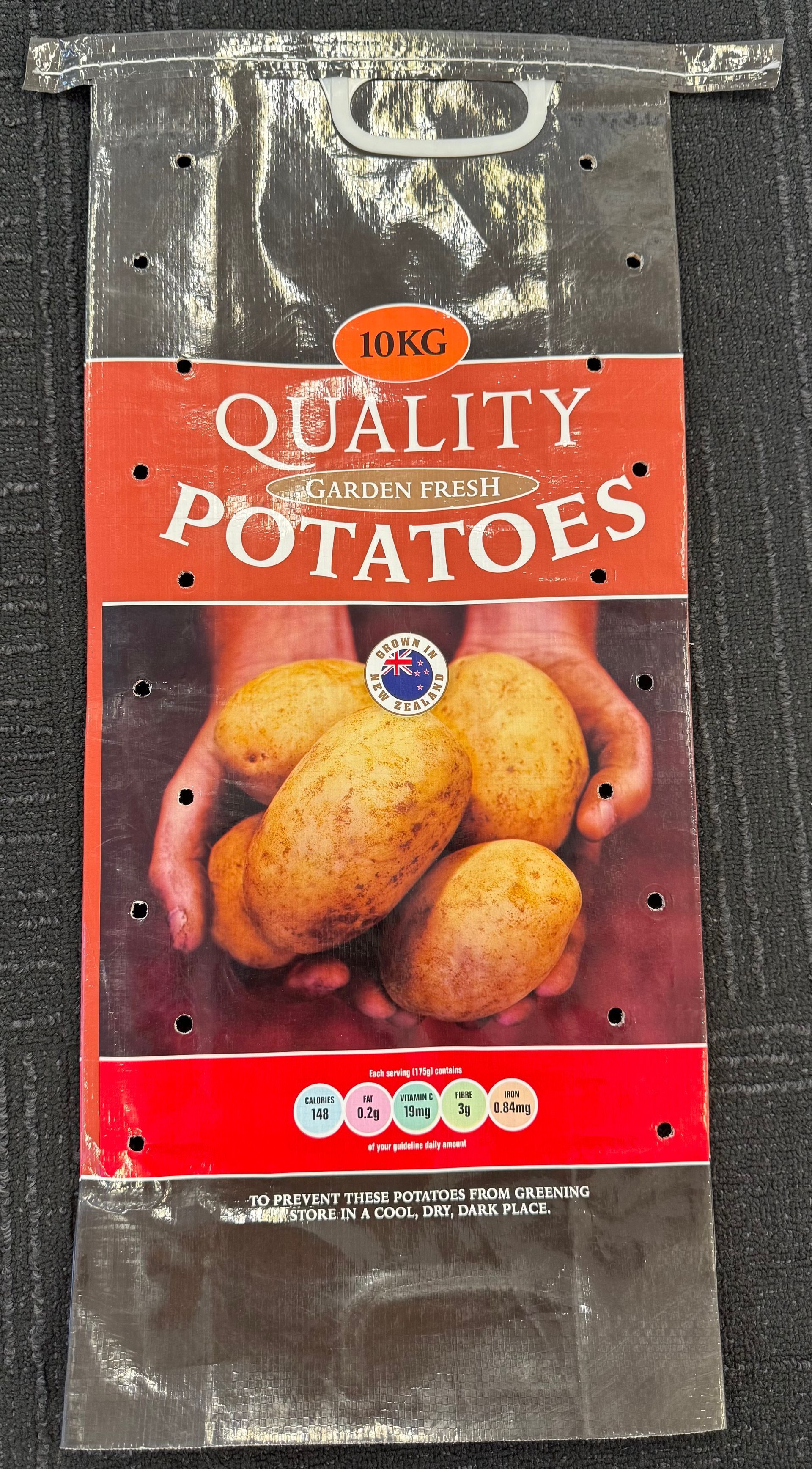 Package of quality potatoes with red label and photo of potatoes on a clear plastic bag