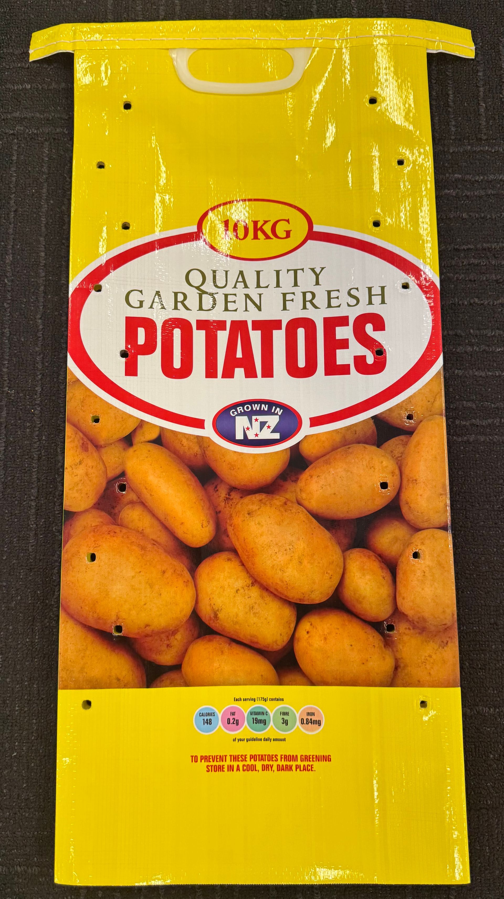 Yellow bag of fresh potatoes with a clear plastic window showing potatoes inside.