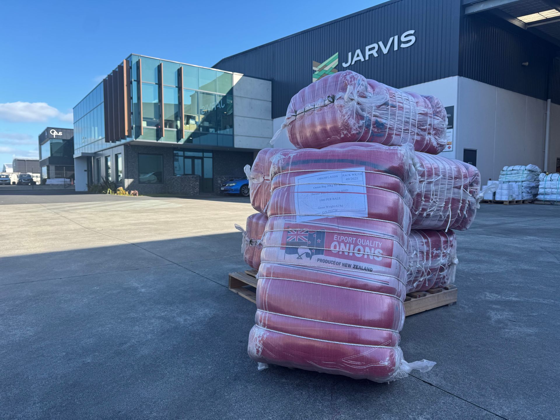 Pallet of wrapped red bags outside a JARVIS warehouse on a sunny day