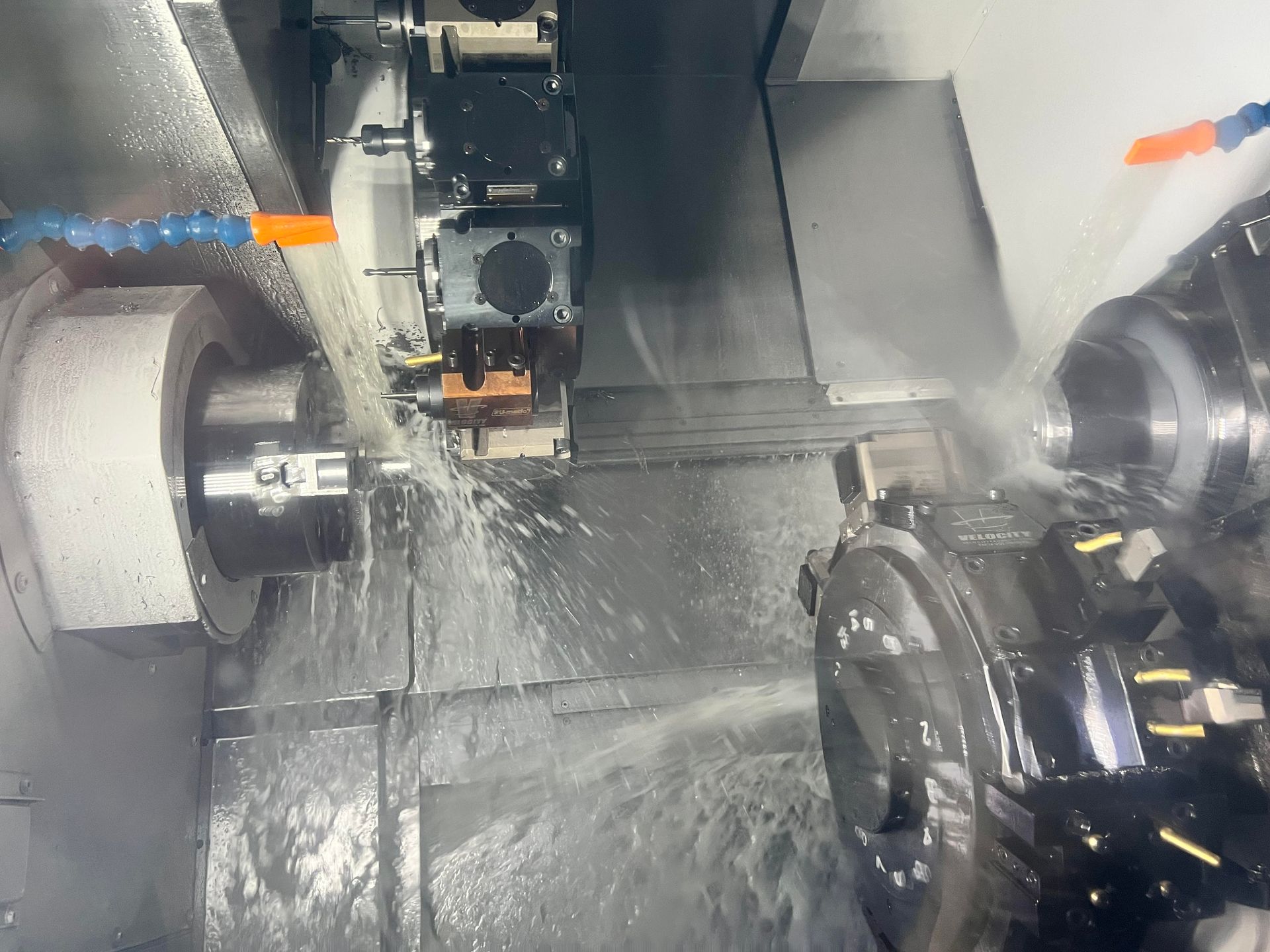 A machine is cutting a piece of metal with water coming out of it.