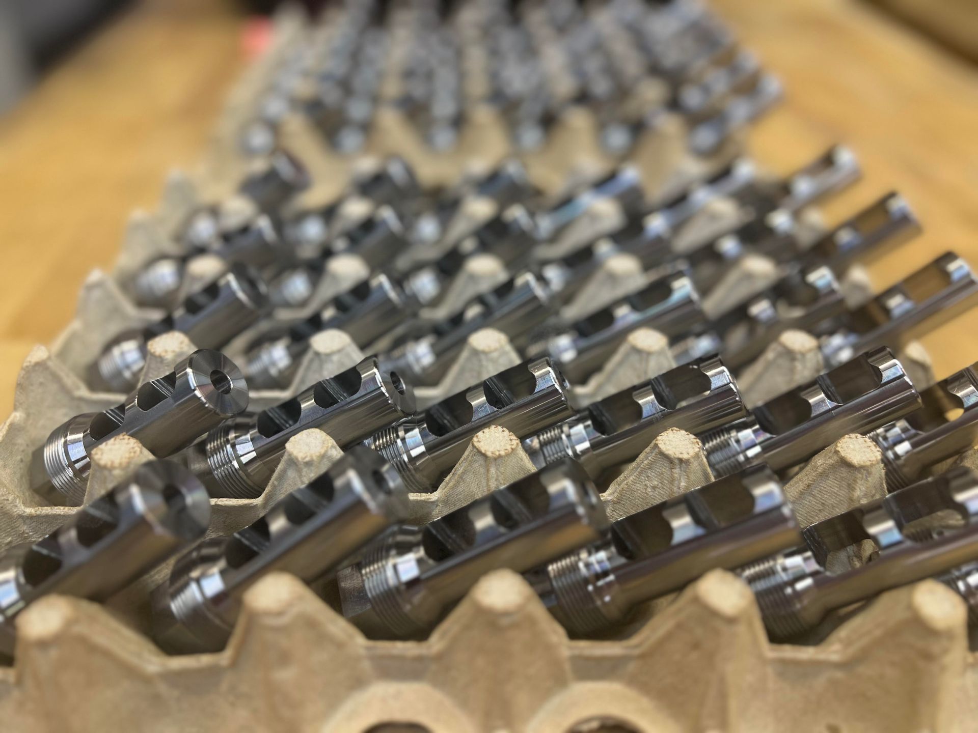 A close up of a cardboard tray filled with lots of pieces of metal.