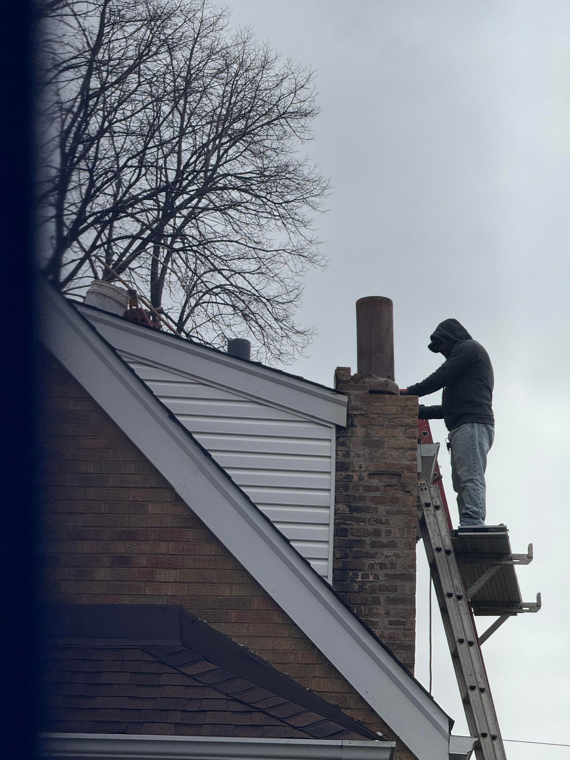guy on ladder next to roof