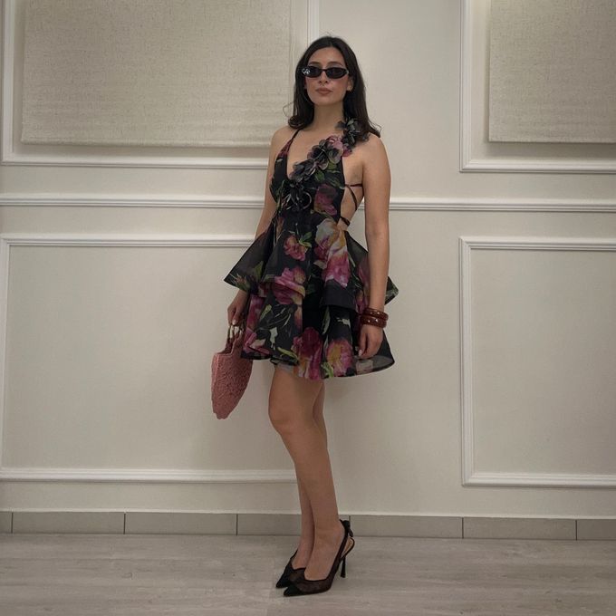 Una donna vestita di bianco è in piedi su un balcone.
