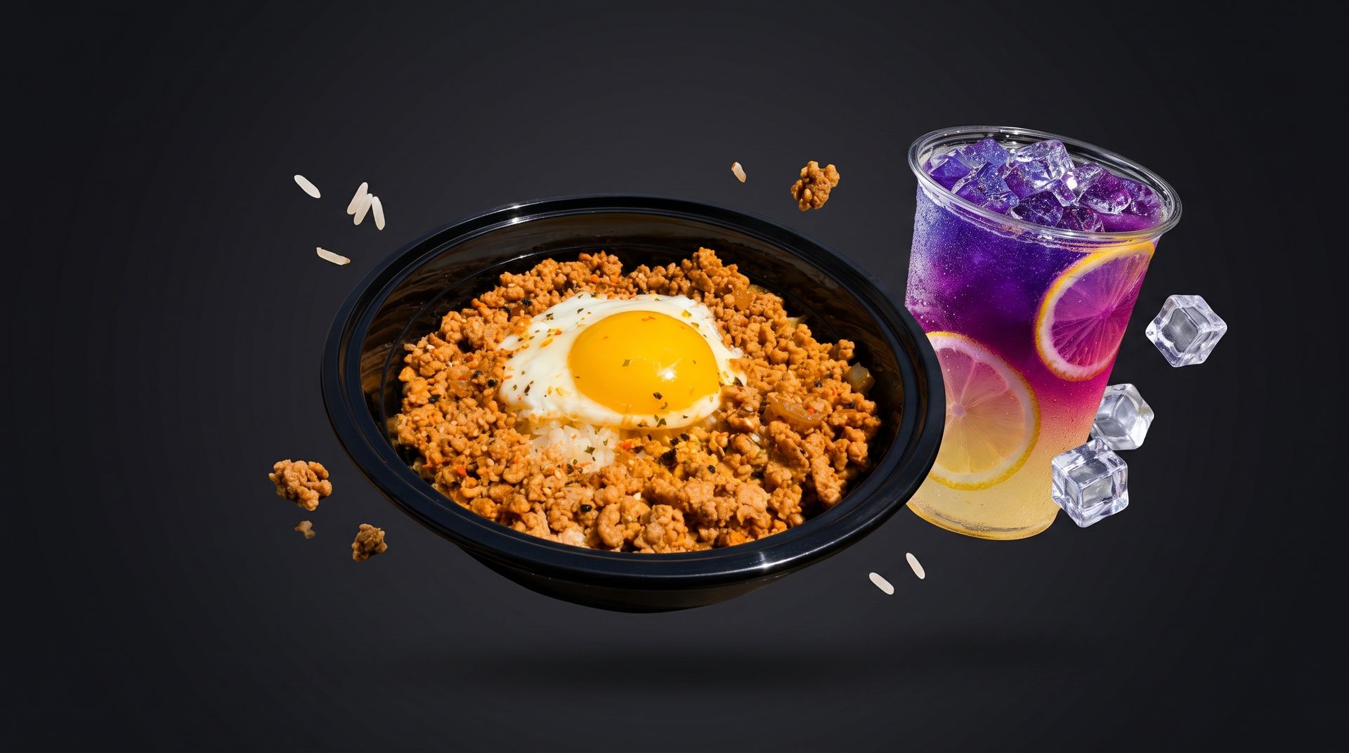 Black bowl of rice topped with a sunny-side-up egg beside a purple iced drink and ice cubes